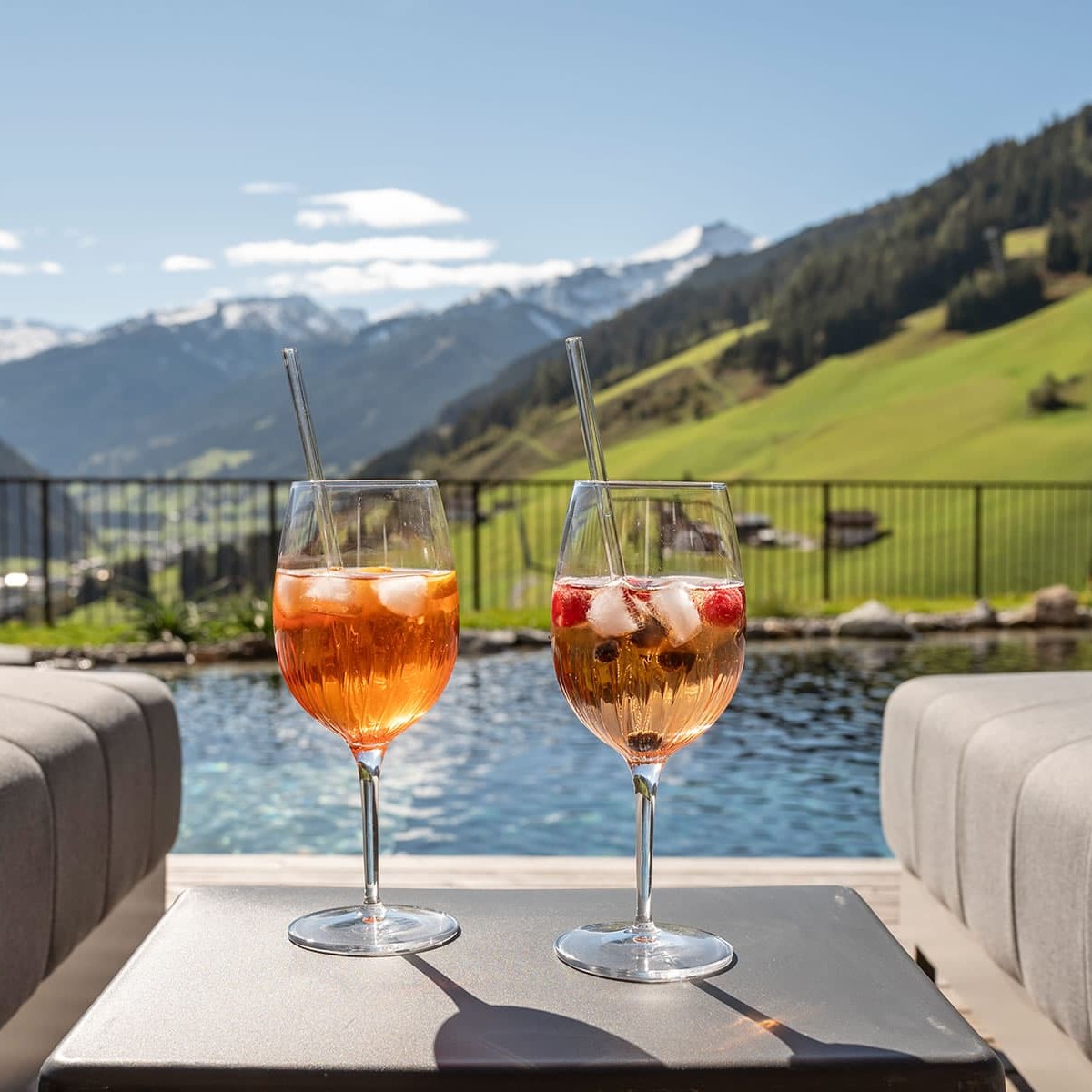 Bei einem Glas Aperol Spritz oder einem erfrischenden Lillet am Schwimmteich den Sommertag genießen