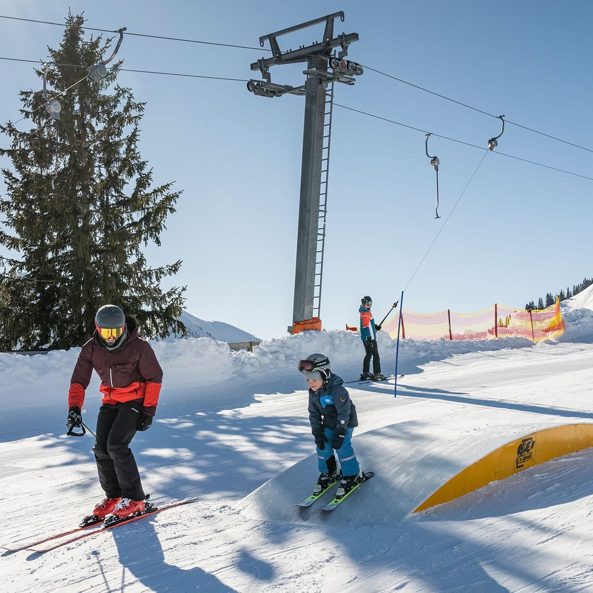 Skifahrer mit Kind auf der Piste